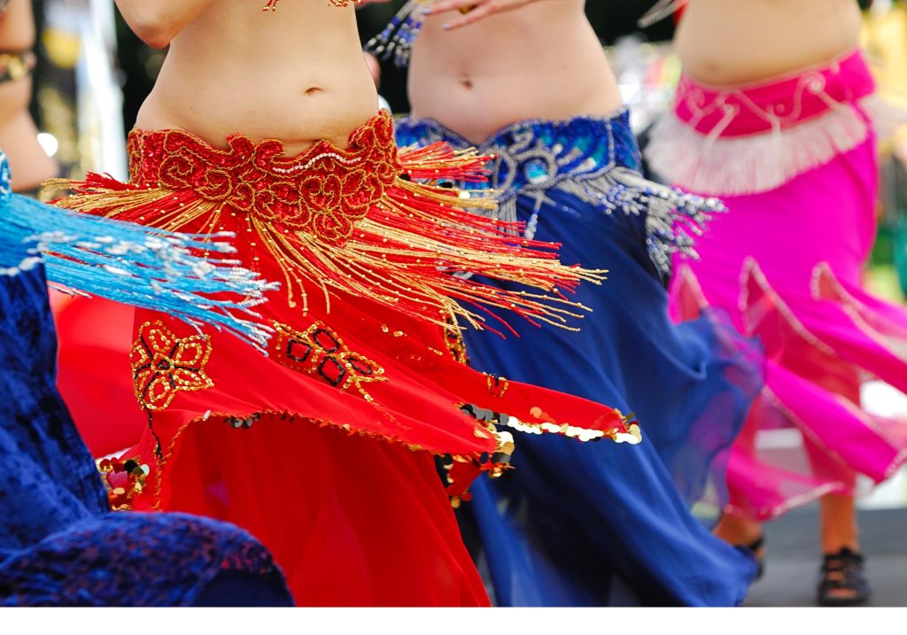 Naiset tanssimassa itämaista tanssia erivärisissä vatsatanssihameissa.